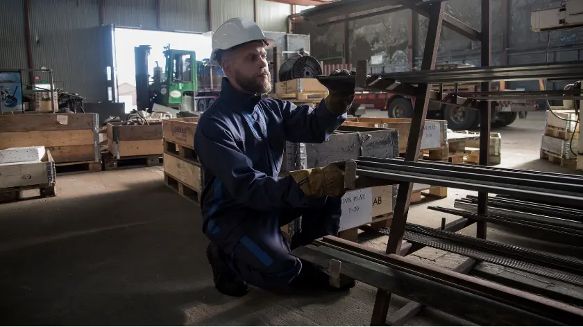 Trabajador revisando componentes metálicos durante un proceso de producción industria